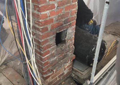 Wall removed. chimney, wires and plumbing still to go